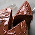 A piece of chocolate cake being removed from the whole